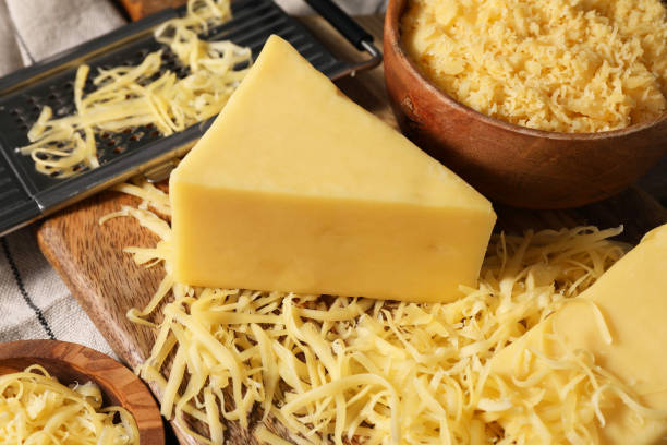 istock Grated and whole piece of cheese on table, closeup 2158327637