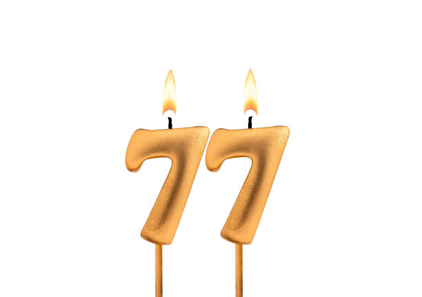 istock Birthday number 77 - Golden candle on white background 2158332880