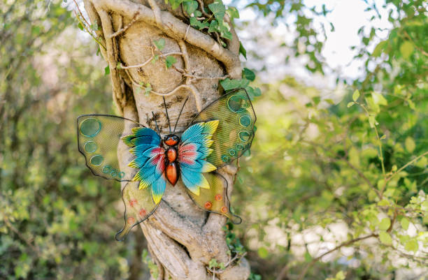 istock Large colorful artificial butterfly sits on a tree in a sunny park 2158333279