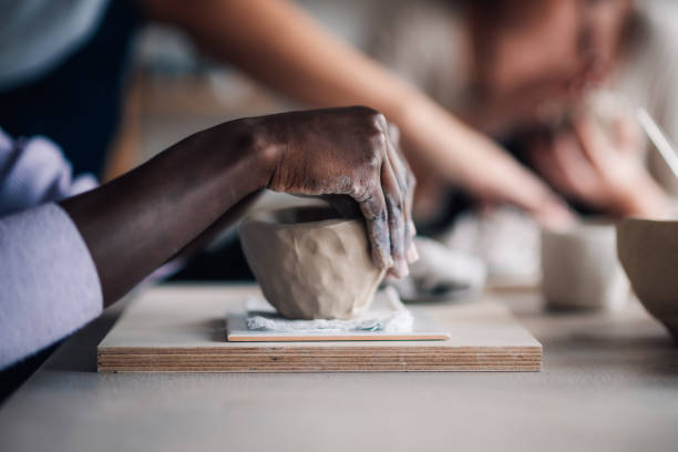 istock Close up of diverse pottery class attendee's hands modeling clay. 2158334179