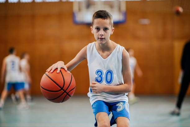 istock Boy with intense gaze playing basketball 2158334199