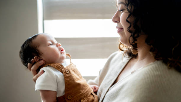 istock Young Hispanic mother cares for her newborn infant son 2158334251