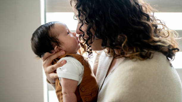 istock Young Hispanic mother cares for her newborn infant son 2158334291
