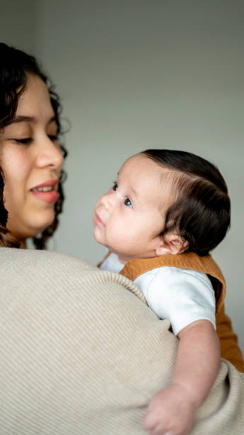 istock Young Hispanic mother cares for her newborn infant son 2158334443