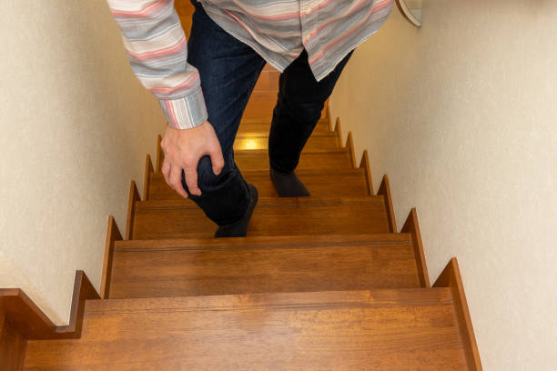 istock A man climbs the stairs with his hand on his knee 2158334500