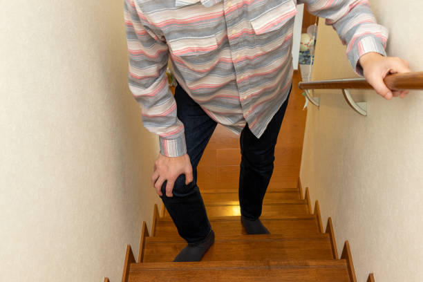 istock A man climbs the stairs with his hand on his knee 2158334506