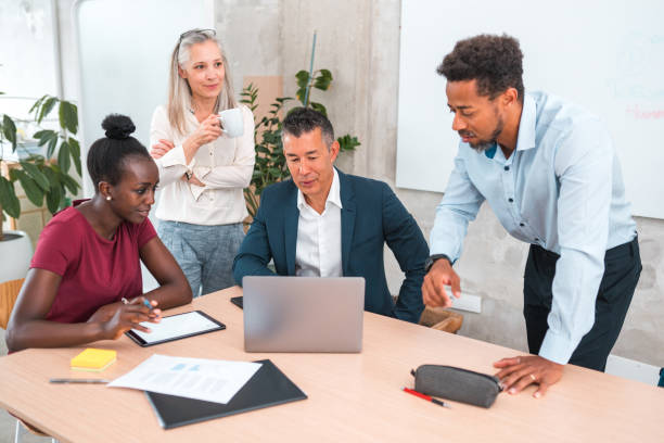 istock Diverse Professionals in Modern Office with Laptop 2158336474