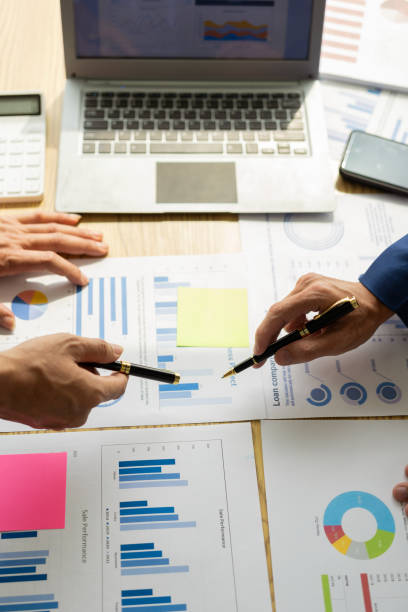 istock Business groups use tablets to analyze company budget report graphs and brainstorm plans for the future. Vertical close-up image 2158337049