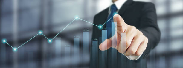 istock Businessman with chart financial symbols coming from hand 2158337734