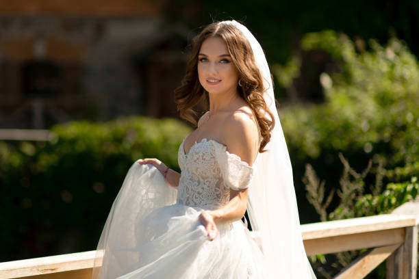 istock White bride in a wedding dress looks at the camera 2158340689