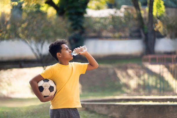 istock Boy drinking water in the public park 2158341904
