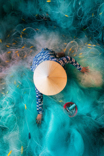 istock Woman knitting turquoise fishing net net 2158355339