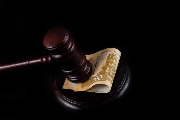 Judge's gavel and 100 Russian ruble bill on a black background