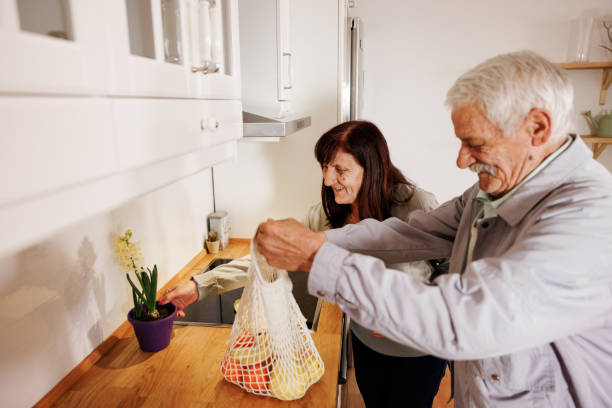 istock Senior couple bringing groceries to their kitchen 2158357267