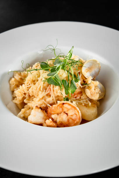 istock Delicious Seafood Risotto with Scallops and Shrimp in a White Bowl 2158358730
