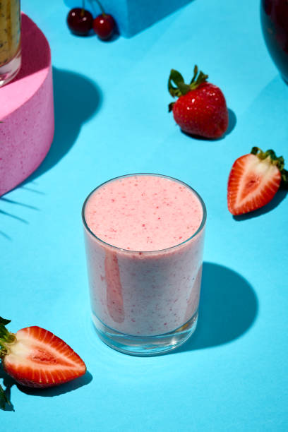 istock Refreshing Strawberry Smoothie in a Glass Surrounded by Fresh Strawberries on a Blue Background 2158358824