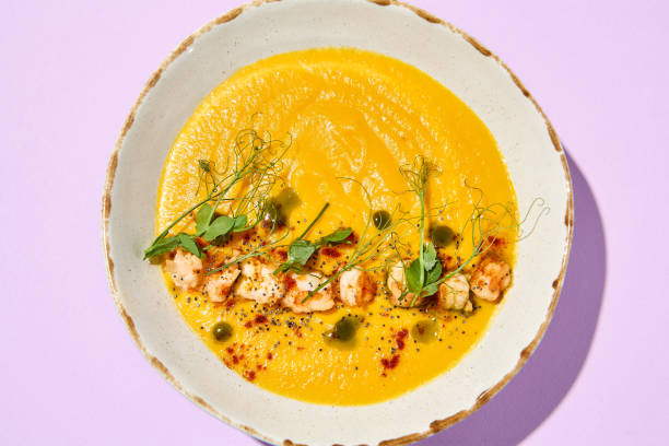 istock Gourmet Pumpkin Cream Soup with Shrimp Garnish on Pastel Background 2158358896