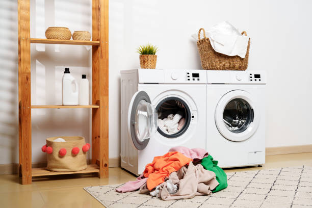 istock White Laundry Appliances With Colorful Clothes Overflowing From Washing Machine 2158360495