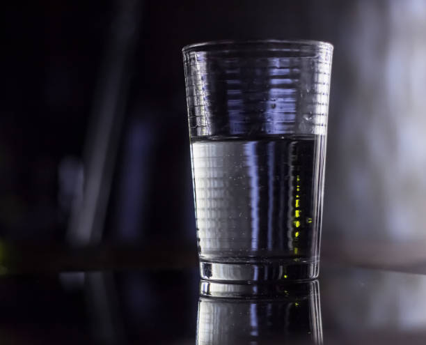 istock A GLASS GLASS WITH WATER HALF FULL, DEFOCUSED BACKGROUND 2158361470