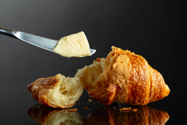 istock Fresh baked croissant with butter on a black background. 2158362053