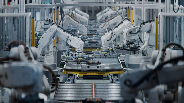 istock Industrial Robot Arms Assemble Lithium-Ion EV Battery Pack. Electric Car Manufacturing Inside Automotive Smart Factory. Row of White Robotic Arms at Automated Production Line at Bright Modern Factory. 2158369994