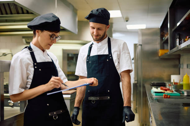 istock Two professional chefs going through order list and working in restaurant. 2158371520