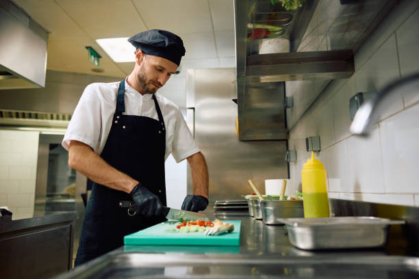 istock Restaurant cook chopping food while preparing meal in the kitchen. 2158371522