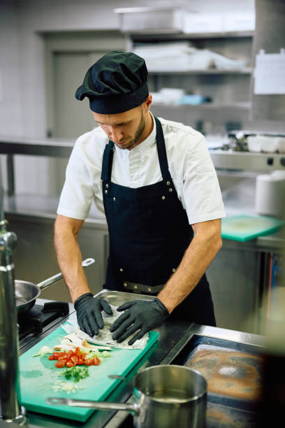 istock Mid adult man working as chef in the kitchen at restaurant. 2158371531
