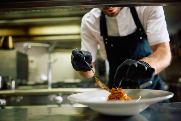 istock Close up of professional cook serving pasta in restaurant. 2158371634
