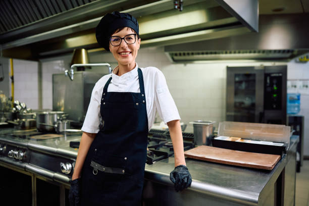 istock Happy female chef working in the kitchen and looking at camera. 2158371744
