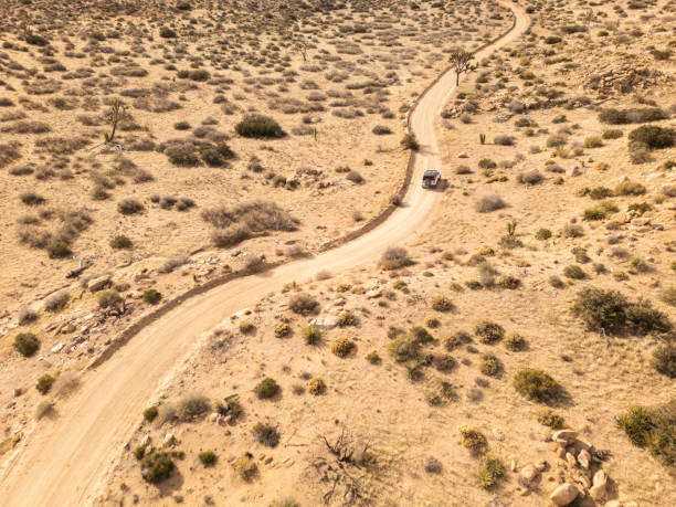 Broken down vehicle with front wheels deep in the sand of the desert