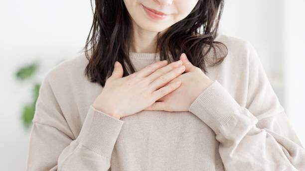 A woman who feels happy with her hands on her chest stock photo