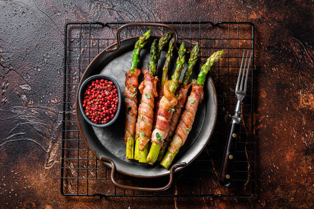 istock Baked Prosciutto wrapped green asparagus. Dark background. Top view 2158372997