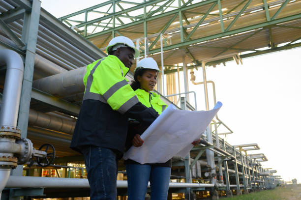 istock Male and female engineers check the drawing system inspection with the real pipe system of the new construction project, engine engineer, Sysetm cooling machine, compared to drawing design. 2158374202