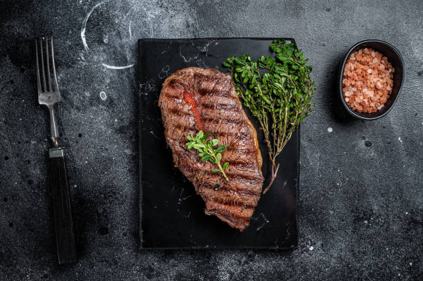 istock BBQ roasted Shoulder Top Blade or Australia wagyu oyster blade beef steak. Black background. Top View 2158374888