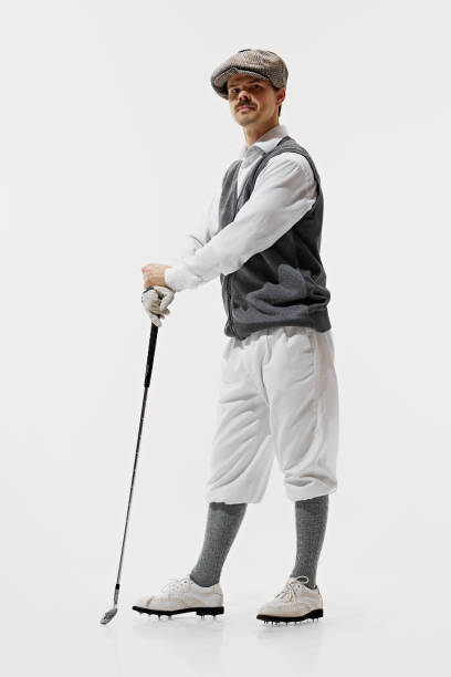 20th-century sports attire ads. Elegant young man in classical clothes standing with golf club isolated on white background. Concept of sport, retro and vintage, active lifestyle, hobby