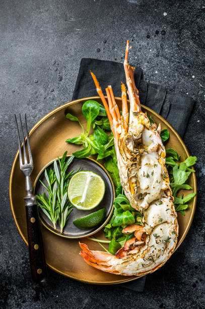 istock Grilled Spiny lobster with salad on a plate. Black background. Top view 2158376372