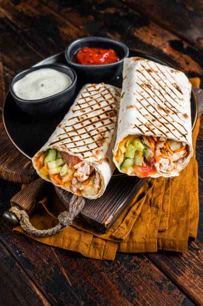 istock Shawarma, Shaurma chicken roll  with  vegetable salad. Wooden background. Top view 2158378228