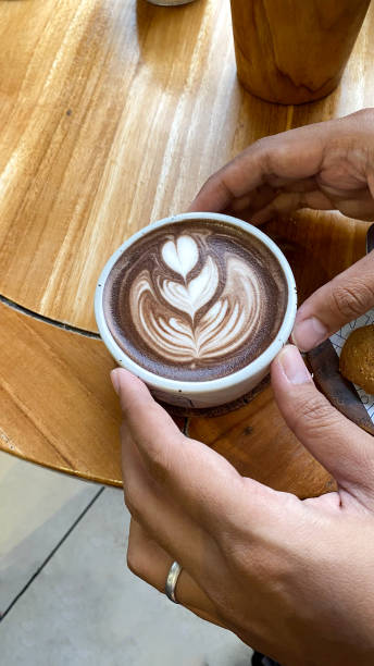 istock someone is holding a cup of coffee with a heart in it. 2158379824