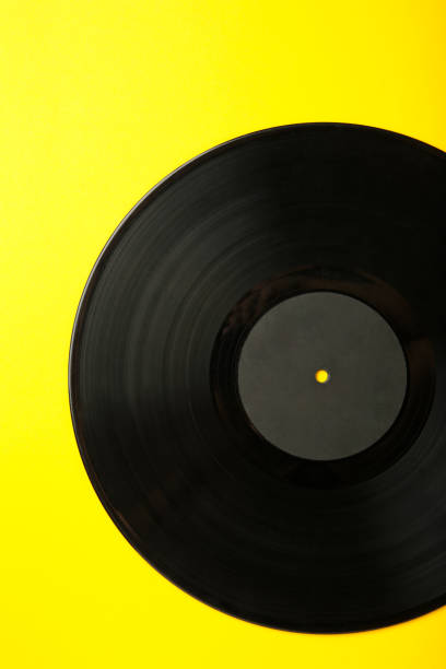 istock Gramophone vinyl record on yellow background. Vertical photo 2158379981