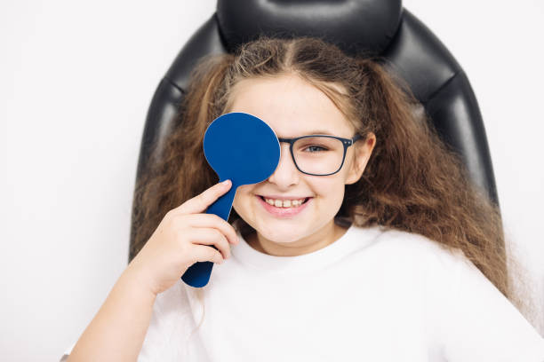 istock Cute baby testing visual acuity with one eye closed. Concept of ophthalmic diagnostics and vision treatment. 2158380659