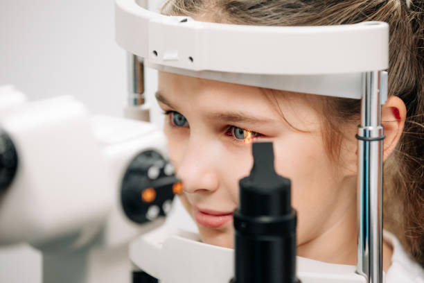 istock Examination of the child using a slit lamp. Microscope and focused light source. A device for high-precision examination of the eye to determine the condition of the lens. 2158381136