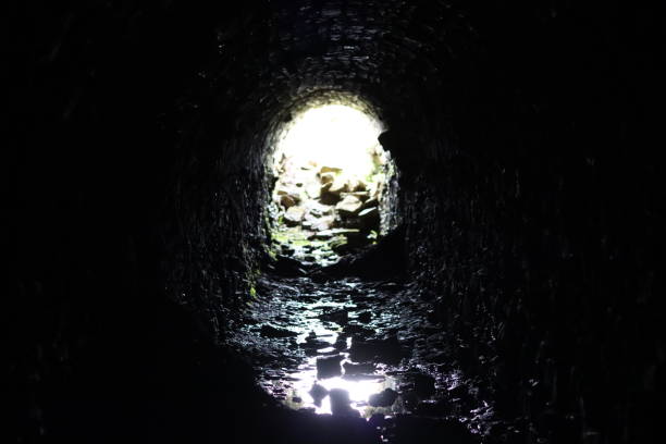 istock Light at the end of a long stone tunnel 2158381248