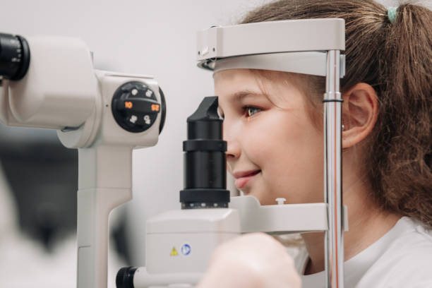 istock Examination of the child using a slit lamp. Microscope and focused light source. A device for high-precision examination of the eye to determine the condition of the lens. 2158381320