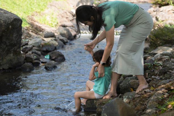 istock Mother and son explore nature on small river 2158381919
