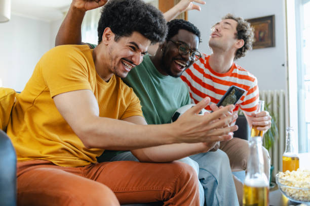 istock Excited group of men watching sports and using smart phone 2158382849