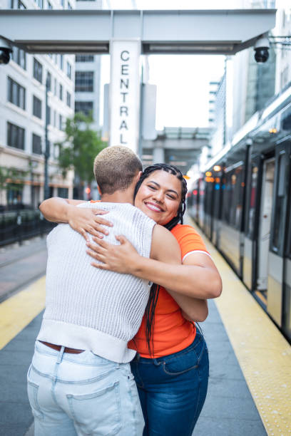 istock Friends reuniting with a warm embrace at a train station 2158383108