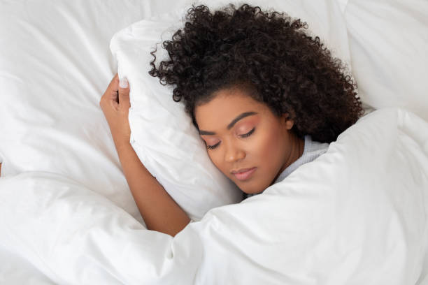 istock Hispanic Woman Sleeping in Bed With White Sheets 2158385898