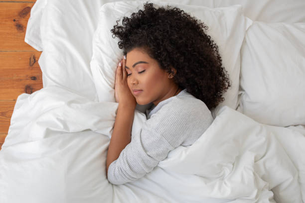 istock Curly Woman Laying in Bed With Head in Hands 2158385902