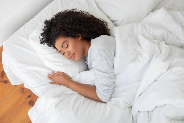 istock Woman Laying in Bed With White Comforter, View Above 2158385908
